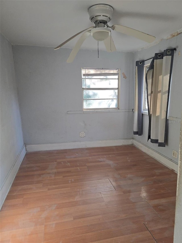 empty room with hardwood / wood-style floors and ceiling fan