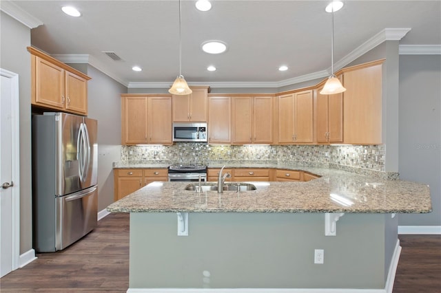 kitchen featuring a breakfast bar, pendant lighting, stainless steel appliances, and sink