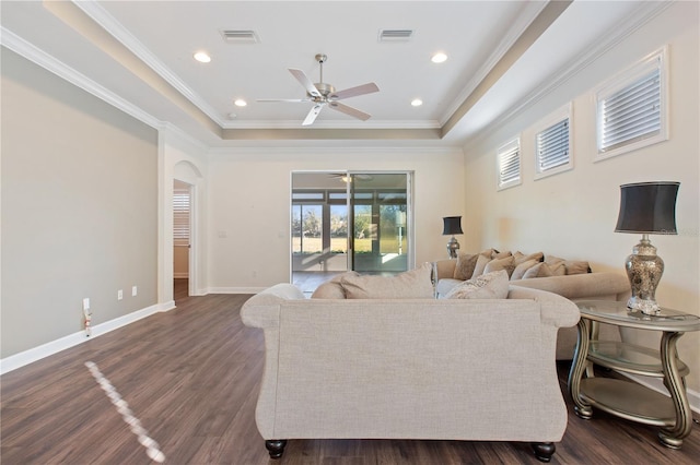 living room with dark hardwood / wood-style floors, ceiling fan, a raised ceiling, and crown molding