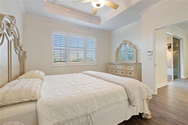 bedroom with ornamental molding, dark hardwood / wood-style floors, ceiling fan, and a tray ceiling