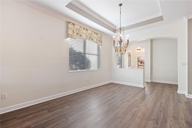 spare room with a raised ceiling, crown molding, dark hardwood / wood-style flooring, and a chandelier