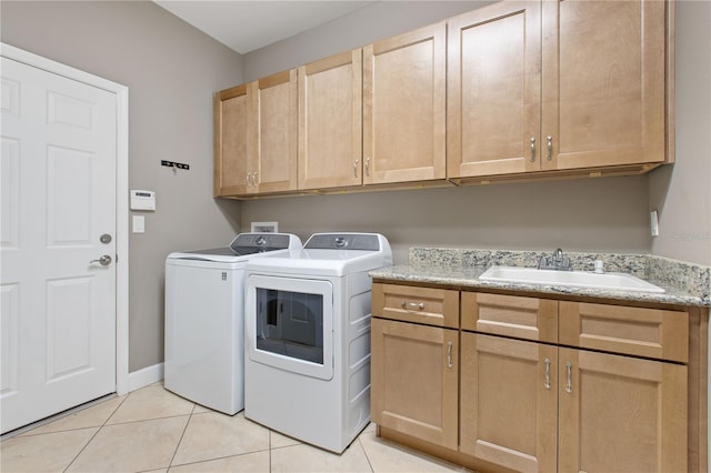 laundry room featuring washer and dryer, cabinets, light tile patterned floors, and sink