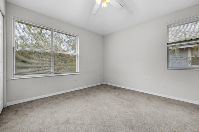 carpeted empty room featuring a wealth of natural light and ceiling fan