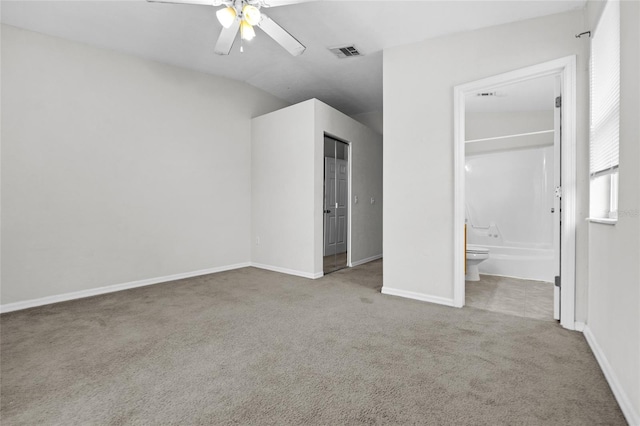 unfurnished bedroom featuring carpet, ceiling fan, ensuite bathroom, and a closet