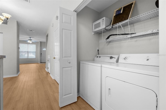 laundry area featuring ceiling fan, washer and clothes dryer, and light hardwood / wood-style floors