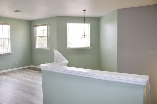 hall with hardwood / wood-style floors and a textured ceiling