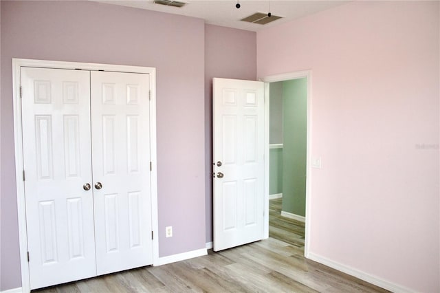 unfurnished bedroom featuring light hardwood / wood-style floors and a closet