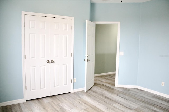 unfurnished bedroom featuring light wood-type flooring and a closet