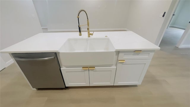 details with sink, white cabinets, and stainless steel dishwasher