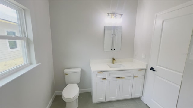 bathroom with toilet, vanity, and tile patterned floors