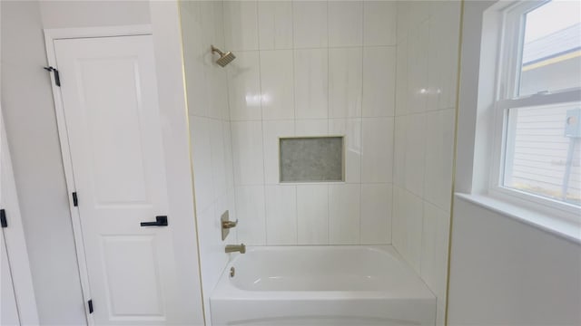 bathroom with a wealth of natural light and tiled shower / bath combo