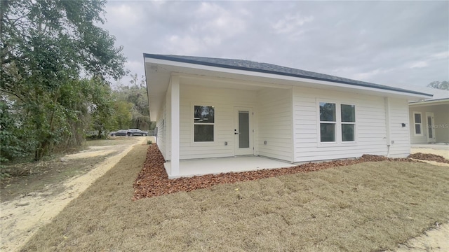 rear view of property with a patio and a lawn