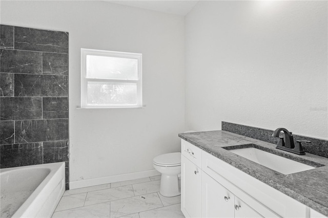 bathroom with a washtub, vanity, and toilet