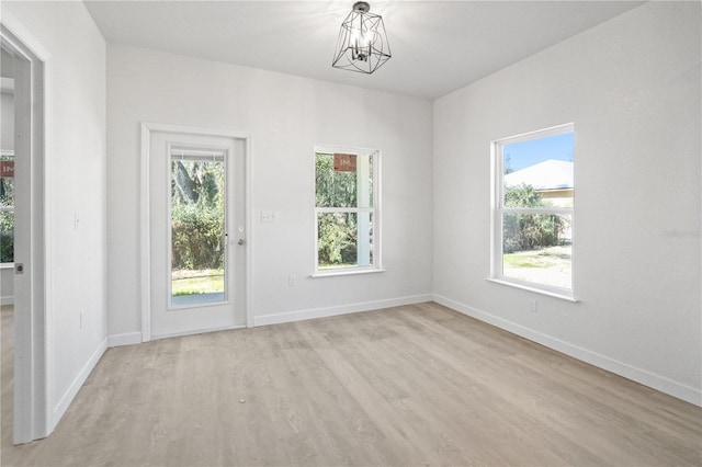 empty room featuring light hardwood / wood-style floors and an inviting chandelier