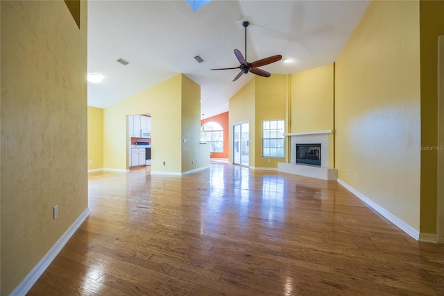 unfurnished living room featuring ceiling fan, a fireplace, high vaulted ceiling, and hardwood / wood-style floors