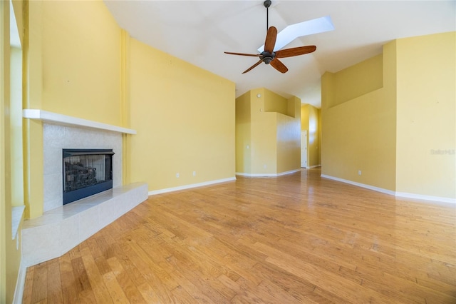 unfurnished living room with a fireplace, hardwood / wood-style floors, vaulted ceiling, and ceiling fan