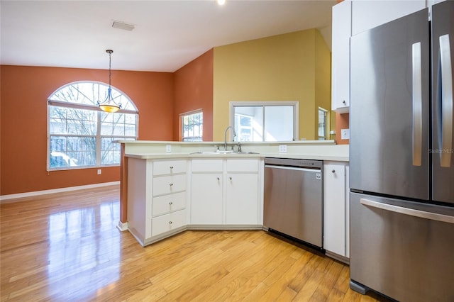 kitchen with white cabinets, appliances with stainless steel finishes, pendant lighting, and sink