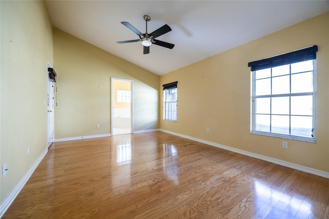 spare room with light hardwood / wood-style floors, vaulted ceiling, a wealth of natural light, and ceiling fan