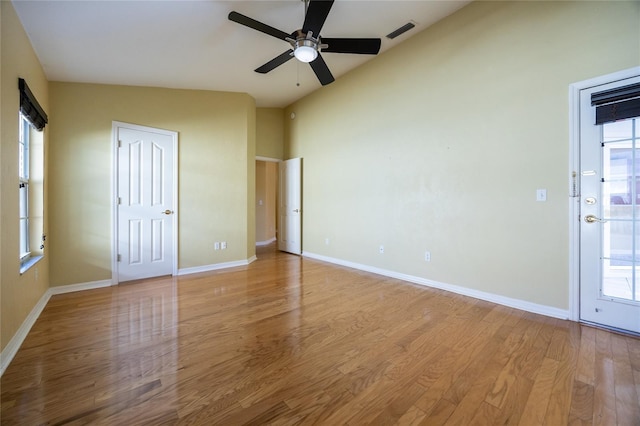 unfurnished room featuring a wealth of natural light, ceiling fan, lofted ceiling, and light wood-type flooring