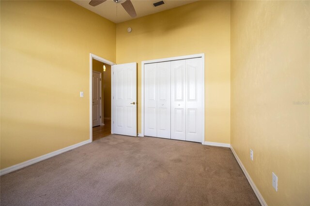 unfurnished bedroom featuring carpet flooring, a closet, and ceiling fan