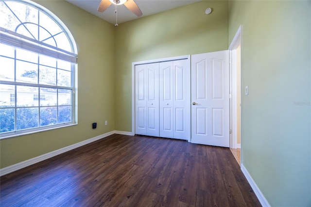 unfurnished bedroom with dark hardwood / wood-style flooring, ceiling fan, and a closet