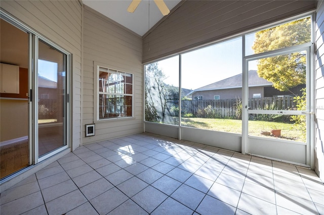 unfurnished sunroom with ceiling fan and vaulted ceiling