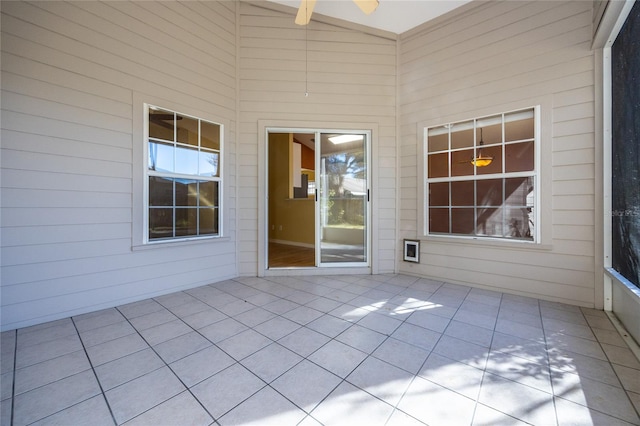 unfurnished sunroom featuring ceiling fan and vaulted ceiling