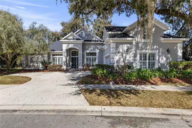 view of front facade featuring an attached garage, concrete driveway, and stucco siding
