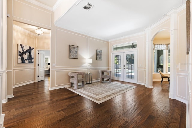 foyer entrance featuring a decorative wall, crown molding, french doors, and visible vents