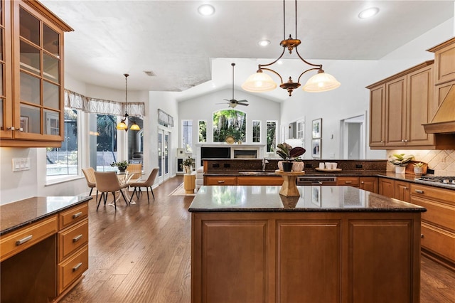 kitchen featuring ceiling fan with notable chandelier, glass insert cabinets, plenty of natural light, and a sink