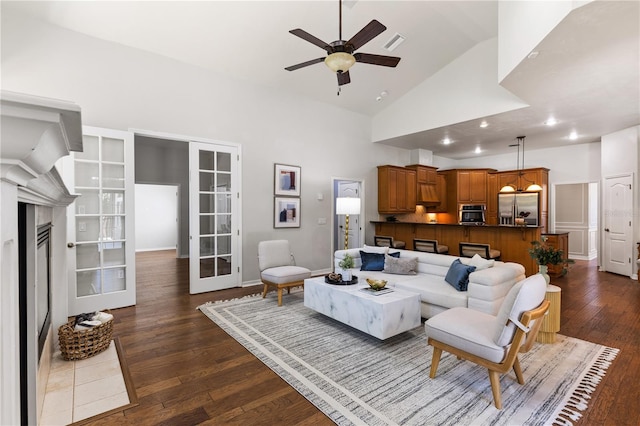 living room with dark wood finished floors, visible vents, recessed lighting, ceiling fan, and high vaulted ceiling