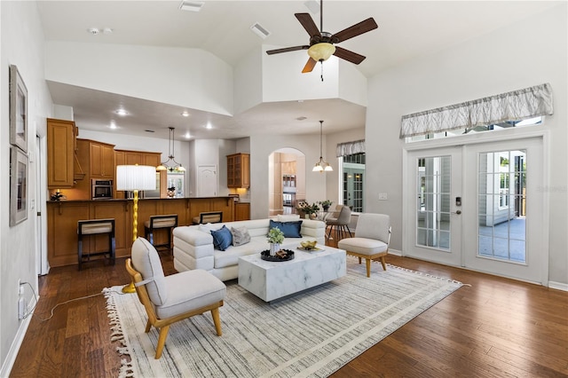 living room with visible vents, a ceiling fan, arched walkways, high vaulted ceiling, and dark wood-style flooring