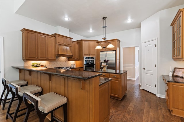 kitchen with backsplash, stainless steel appliances, custom exhaust hood, and brown cabinets