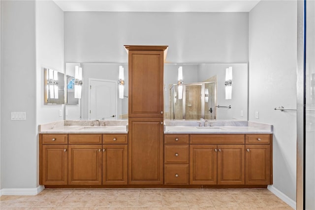 bathroom with baseboards, a sink, double vanity, and a stall shower