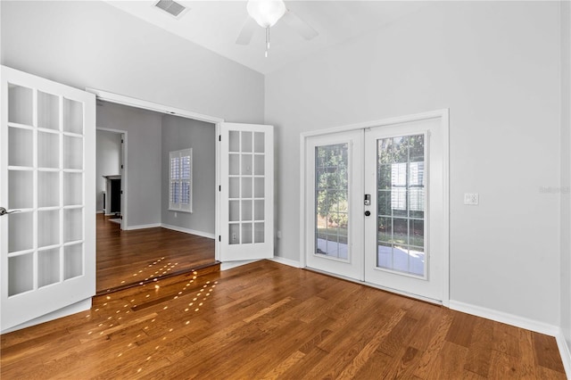 interior space featuring french doors, baseboards, visible vents, a ceiling fan, and wood finished floors