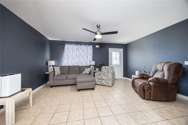 living room featuring a textured ceiling, ceiling fan, and light tile patterned flooring