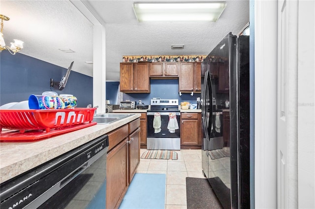 kitchen with black appliances, light tile patterned flooring, sink, and a textured ceiling