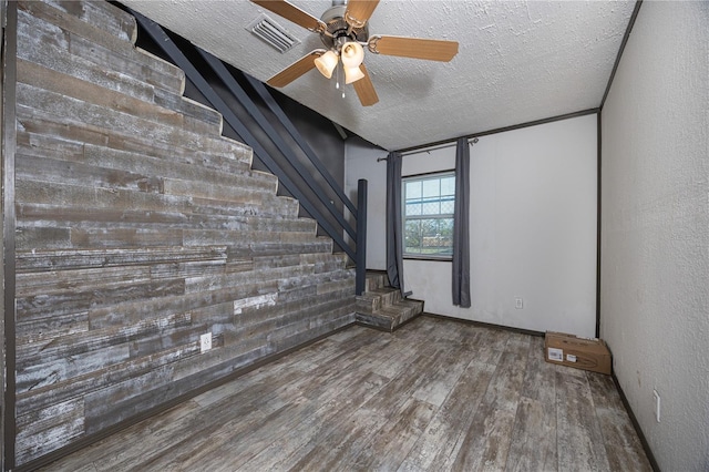 unfurnished room with hardwood / wood-style flooring, ceiling fan, and a textured ceiling