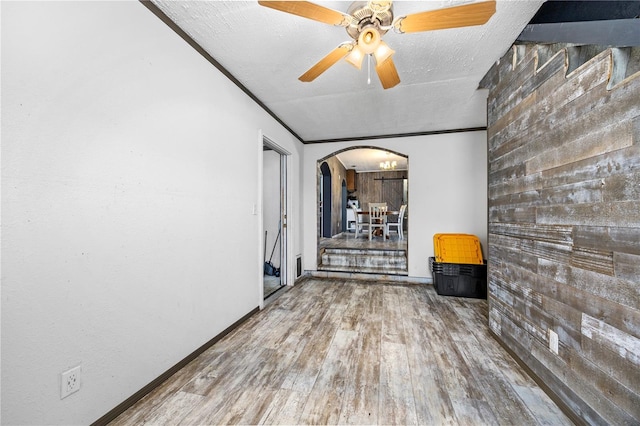 spare room featuring hardwood / wood-style floors, a textured ceiling, ceiling fan, and crown molding