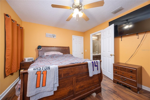 bedroom featuring a textured ceiling, dark hardwood / wood-style floors, ensuite bath, and ceiling fan