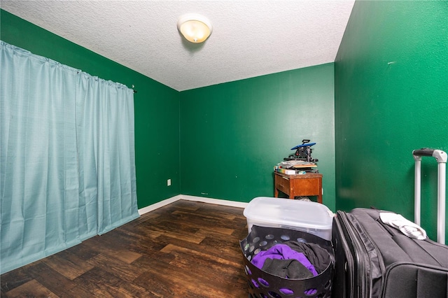 bedroom featuring dark hardwood / wood-style flooring and a textured ceiling