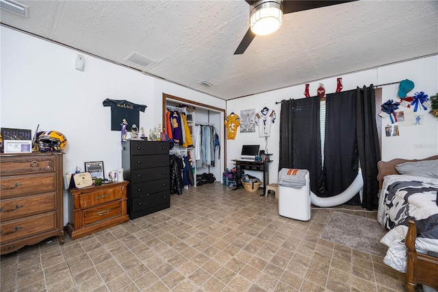 bedroom with ceiling fan, a textured ceiling, and a closet