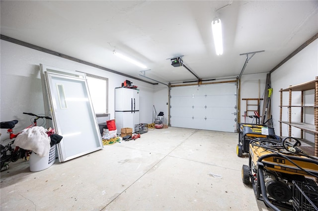 garage featuring white refrigerator and a garage door opener