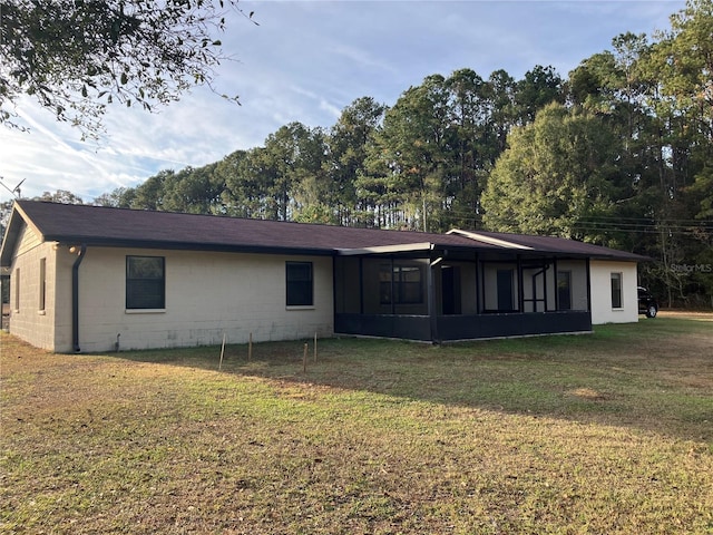 back of house with a lawn and a sunroom