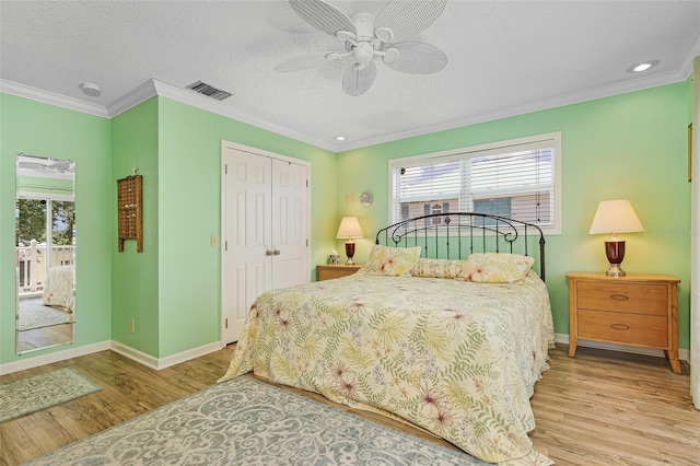 bedroom with ceiling fan, a closet, crown molding, and light hardwood / wood-style floors