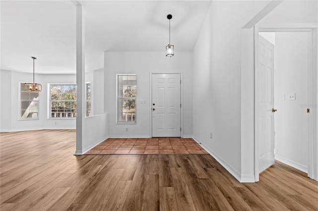 entryway with hardwood / wood-style floors and a notable chandelier