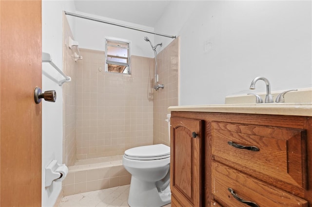 bathroom featuring toilet, tiled shower, and vanity