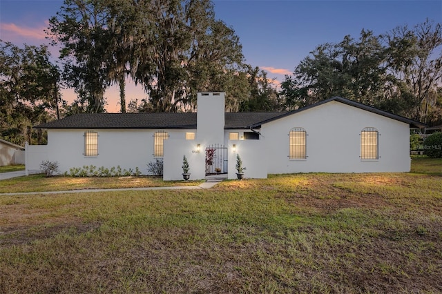 ranch-style home featuring a yard