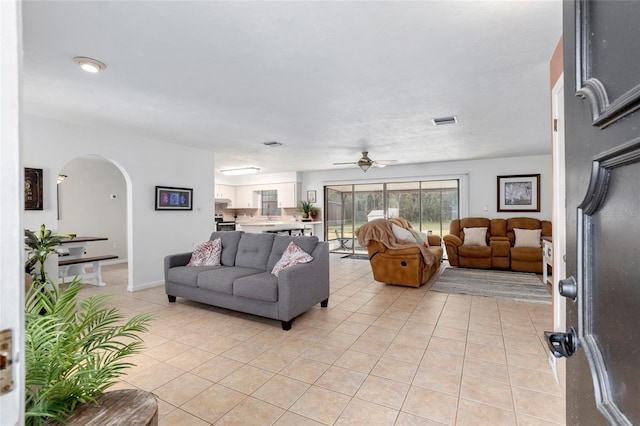 tiled living room with ceiling fan