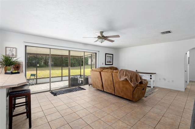 tiled living room featuring a textured ceiling and ceiling fan